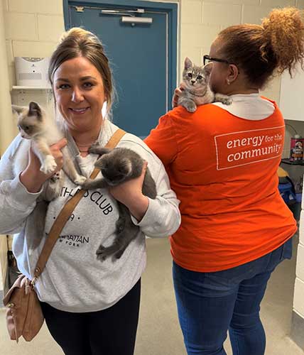 Two employees from Atlantic City Electric visit with some kittens.