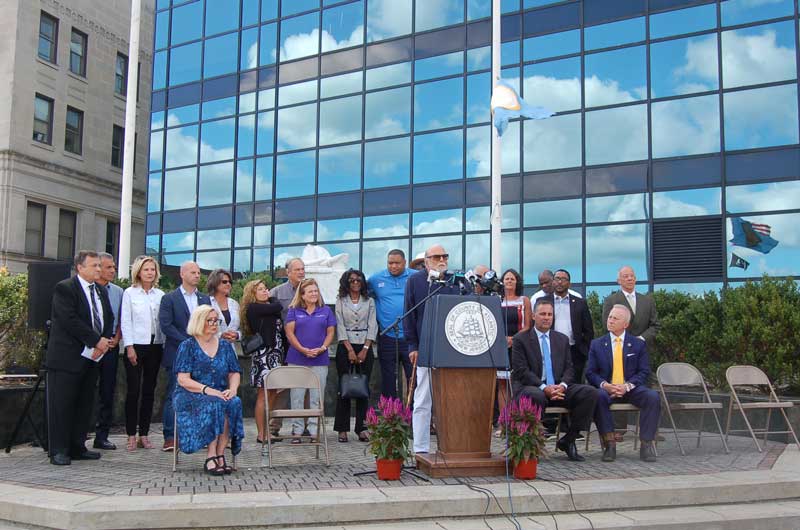 County Executive, Dennis Levison, speaking at press conference surrounded by elected officials.