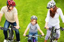 Family riding bikes with helmets.