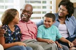 Grandparents sitting down in a home with grandchildren.