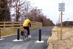 Bikeway with bicyclist wearing a yellow windbreaker.